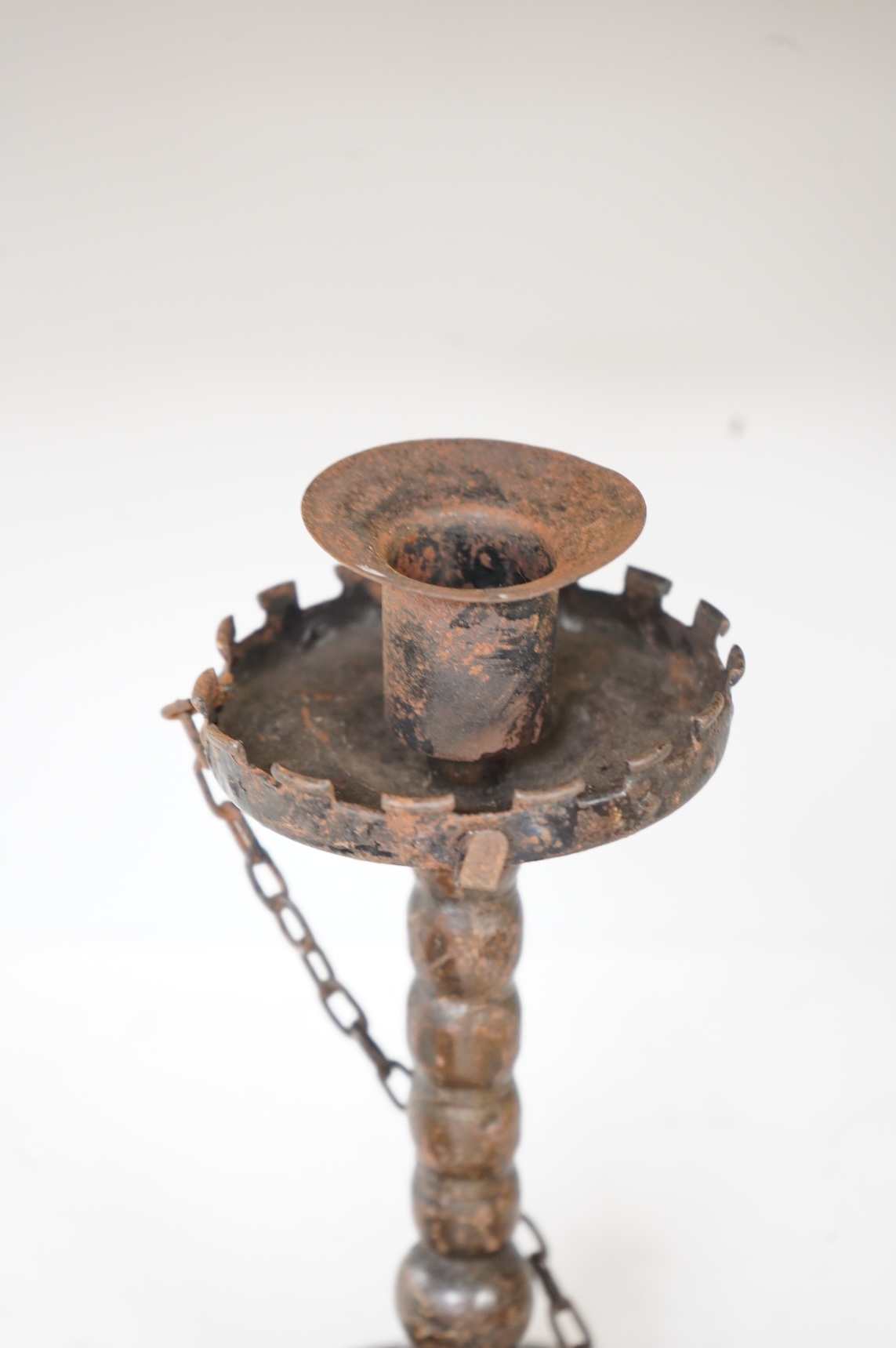 A pair of 19th century toleware wine coasters and an Arts & Crafts iron candlestick with attached snuffer, 21cm high